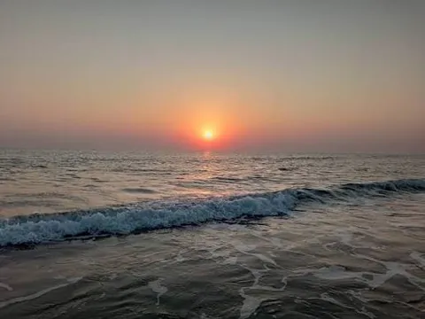 Sun setting over the sea at Chhachhi Beach, with waves breaking on the sand