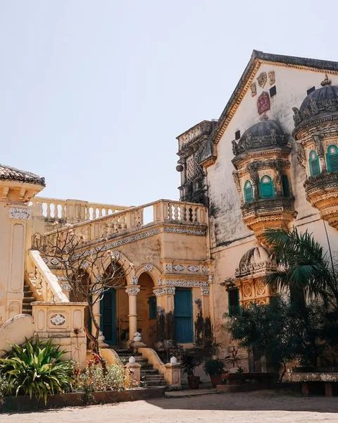 Courtyard of the Devpar darbargadh with carved balconies and a stepped entrance