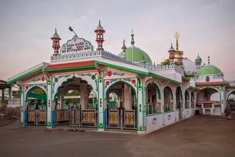 Green-and-white domes and arches of the Hajipir dargah