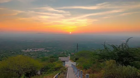 Sunset over the Kutch plains seen from a stepped hill path with railings