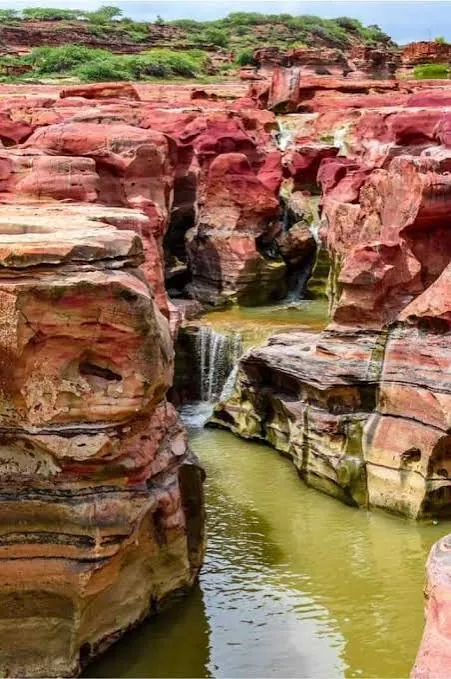Small waterfalls running over red rock ledges at Kadiya Dhro after rain