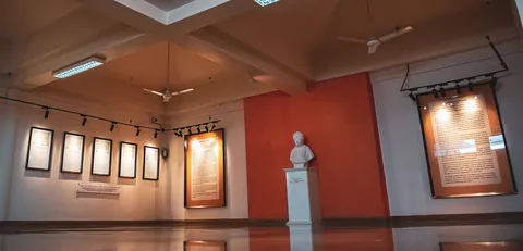 Gallery at Kranti Teerth with framed letters, information panels and a white marble bust