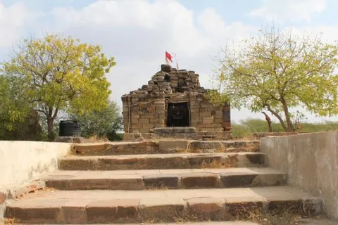 Small stone shrine with a red flag at the top of stone steps, Paddhar Gadh