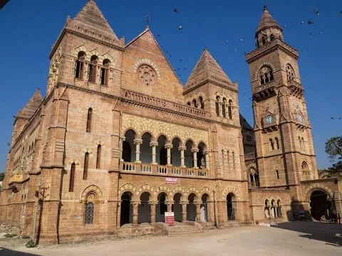 Prag Mahal in Bhuj, a sandstone Gothic palace with arched balconies and a clock tower