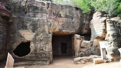 Rock-cut entrance of the Siyot Caves in a sandstone outcrop
