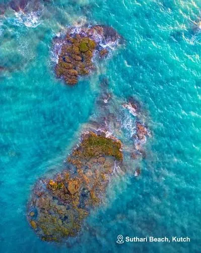 Aerial view of rocks in turquoise water at Suthari Beach