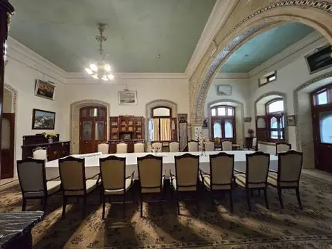 Formal dining hall inside Vijay Vilas Palace with a long table and arched doorways